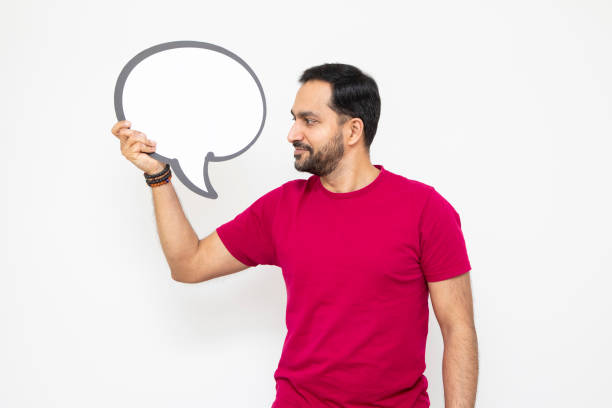 Mid-adult male holding and looking at a blank speech bubble for your message.