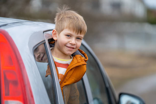 istock Smiling little boy peeping outside car 2022218351