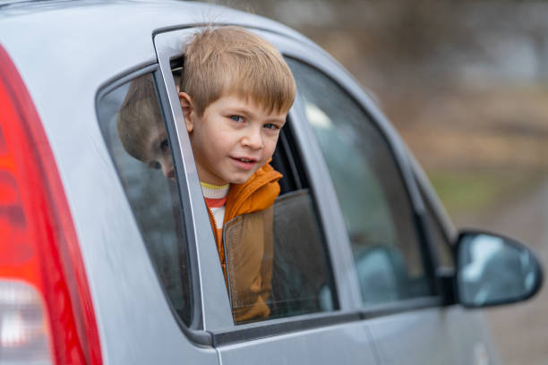 istock Smiling little boy peeping outside car 2022218353