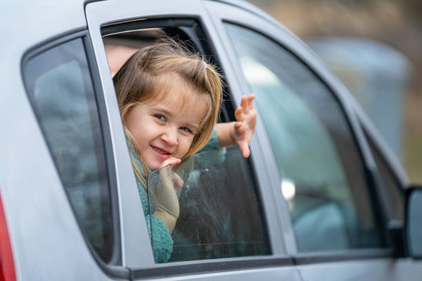 istock Smiling little girl peeping outside car 2022218356