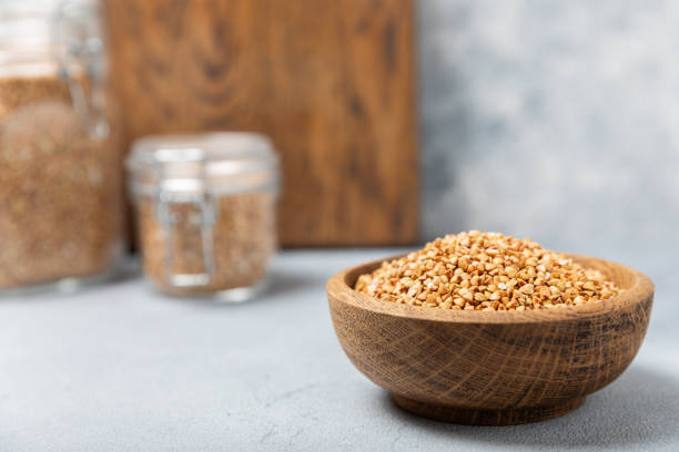 Green buckwheat in a bowl on a wooden kitchen table.Superfood.Raw buckwheat porridge.Healthy vegan food concept, eco products, diet. Copy space.Organic food.weight loss and proper nutrition. trigo sarraceno verde en un cuenco sobre una mesa de cocina de madera. superalimento.gachas crudas de trigo sarraceno. concepto de comida vegana saludable, productos ecológicos, dieta. espacio de copia. alimentos orgánicos.pérdida de peso y nutrición a