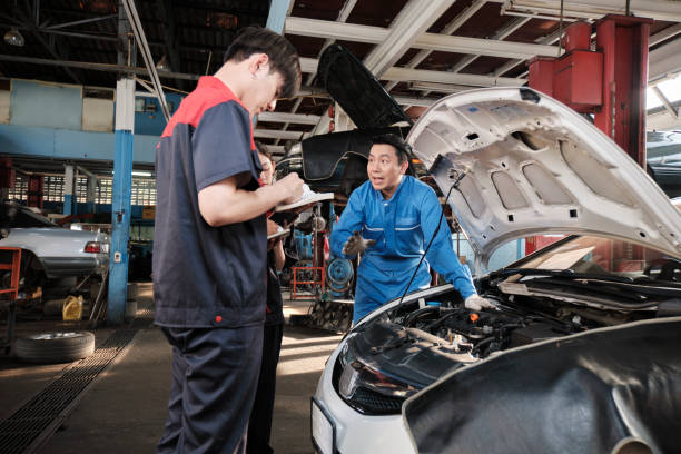 istock Supervisor engineer is teaching mechanic workers about car repair at a garage. 2022223755