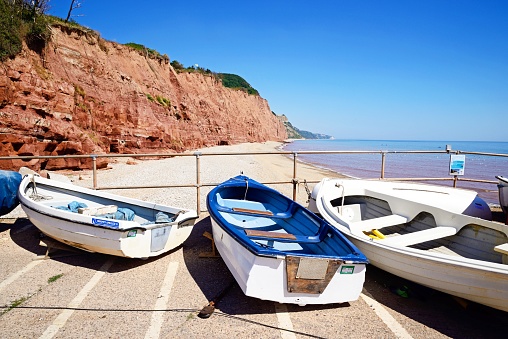 Small fishing boats moored on the slipway with views along the beach at Pennington Point, Sidmouth, Devon, UK, Europe.