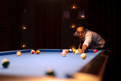 People play billiards at night club. Party and nightlife.