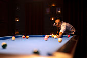 People play billiards at night club.