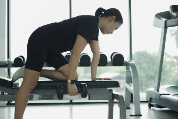 istock Side view woman lifting dumbbells 2022285836