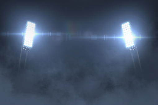 Beautiful bright glowing spotlights in the night with fog. Stadium and championship, creative idea. Free space for design and text, betting creative