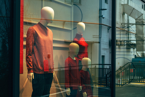 Mannequin with red percentage discount t-shirt in clothing store shopwindow, selective focus