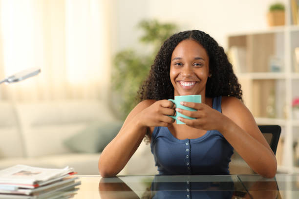 istock Happy black woman drinking coffee looking at you 2022316977