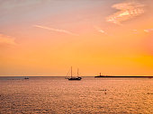 Beautiful sunset over the sea with a sailboat in the foreground
