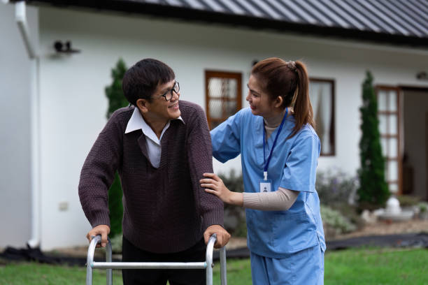 istock Nurse or caregiver helps elderly walk by using walker in garden 2022321898