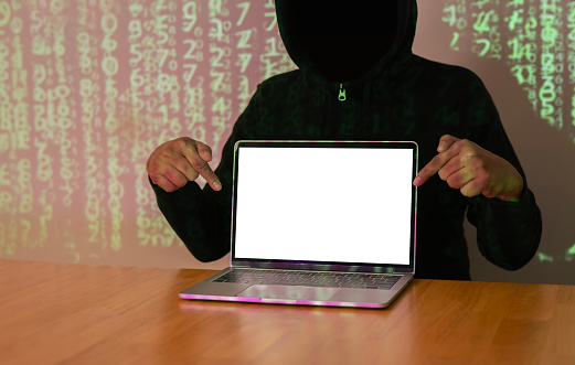 Dark face hacker pointing hands and show laptop while stealing big data and finance information. Copy sapce.
