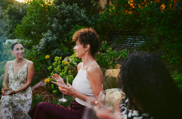 istock Diverse women smiling and talking over drinks during a garden party 2022346948