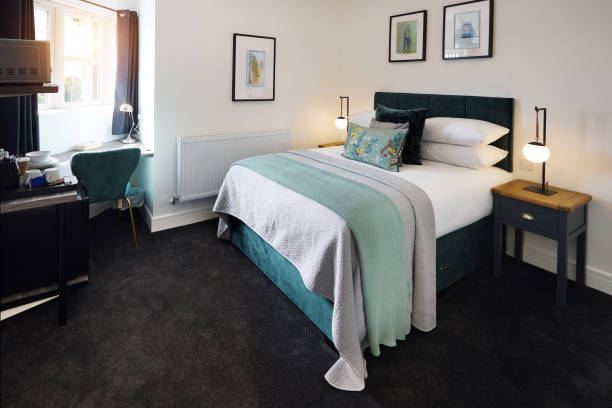 istock Bed, empty room and hotel interior design for accommodation for travel comfort for weekend, holiday or furniture. Lodge, home decor and apartment in London for hospitality rent, vacation or service 2022349146