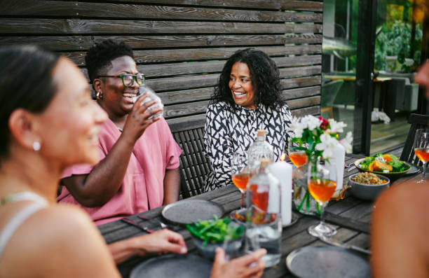 istock Diverse women laughing over drinks together during a patio dinner party 2022351805