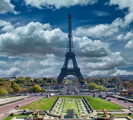 This stunning photograph captures the essence of Parisian charm, featuring the Eiffel Tower standing tall and proud above the Trocadéro Gardens. The gardens provide a lush foreground to the iron lattice tower, which is the symbol of France's innovative spirit and architectural prowess. The dramatic cloudscape above and the tranquil city park below frame this iconic structure beautifully, creating a scene that is quintessentially Paris. This image, with its clear view of one of the world's most recognisable landmarks against a dynamic sky, is perfect for travel, cultural, and historical publications seeking to evoke the romance and elegance of Paris.