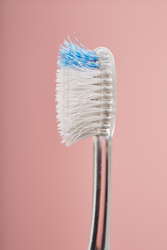 Worn out old plastic toothbrush used with bent bristles in bad condition