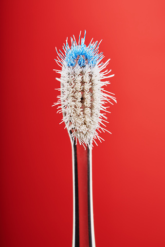 Worn out old plastic toothbrush used with bent bristles in bad condition