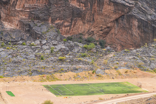 Top view of football playground from spectacular dirt road through Top side view of canyon in Al Hajar Mountains, Oman. It is near Wadi Bani Awf—one of Oman’s most picturesque valleys.