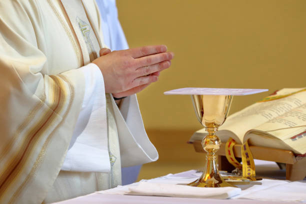 istock Chalice on the altar and priest celebrating mass in the background 2022407730