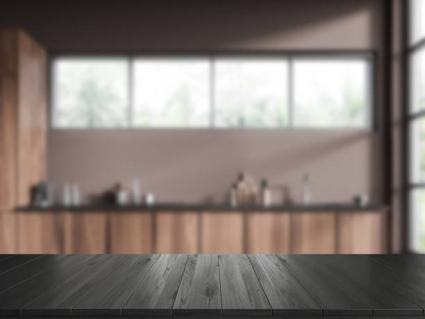 istock Black wooden countertop on background of kitchen interior with window. Mockup 2022428112