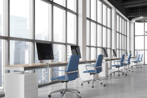 istock Stylish coworking room interior with pc computers on desk, panoramic window 2022428133