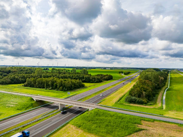 istock Highway through a rural landscape next to a levee and a lake 2022429204