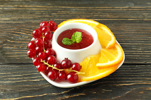 Cranberry sauce and ingredients on wooden background