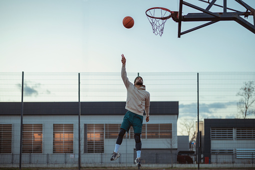 Basketball Player Shooting in a Playground at Dusk. Sport, Active Lifestyle Concept.