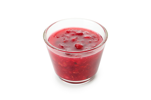 Glass with cranberry sauce isolated on white background