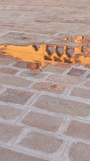 reflection at sunset of Palazzo Ducale in a puddle in Venice, Piazza San Marco