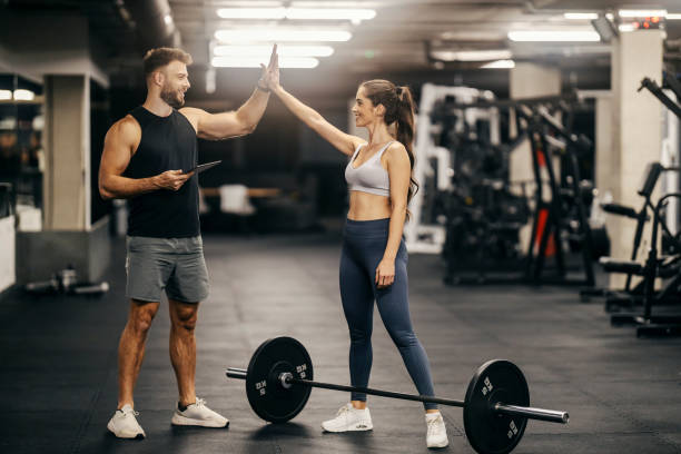 istock A strong sportswoman si giving high five to instructor in a gym. 2022455893