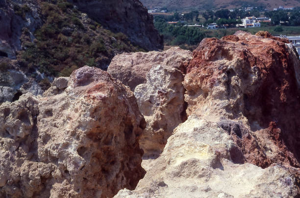 View of rock formations of volcanic origin, made red by the intense volcanic iron emissions active throughout the island, Vulcano, Aeolian Islands, Italy
