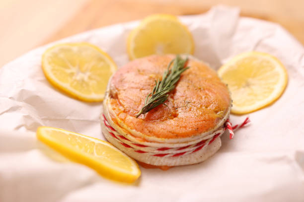 Before baking, put a piece of salmon in a plate on parchment and add lemon