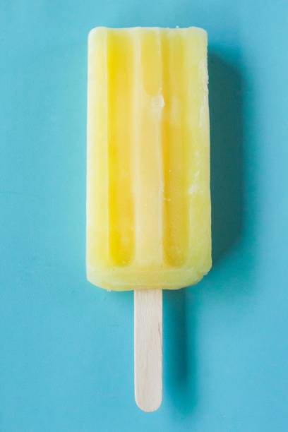istock a yellow ice cream stick, on a blue background 2022484349