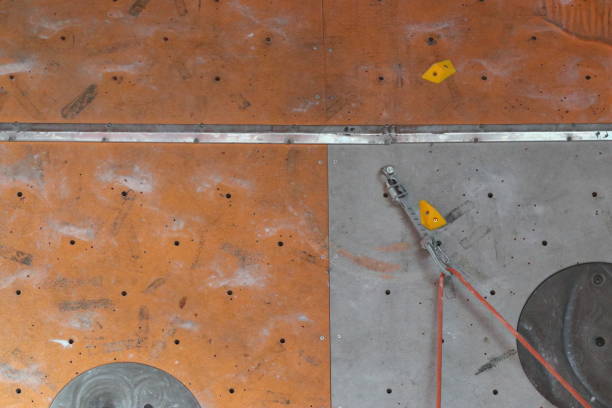 boys during a climbing competition with rope and harness in the gym with colored blocks