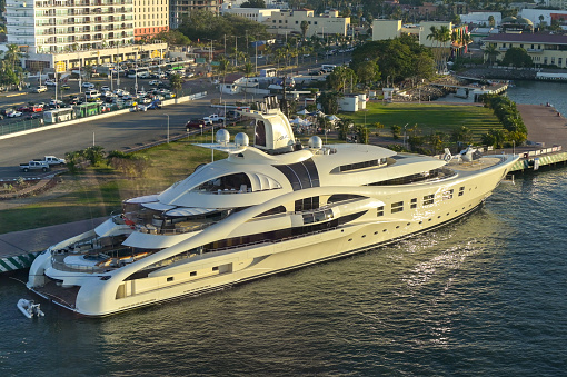 Puerto Vallarta, Mexico - 15 January 2024: Superyacht AV with a helicopter on deck moored in the port of Puerto Vallarta in evening subnlight. It is owned by Dennis Washington.