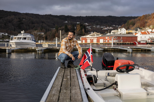 Middle aged man in the port preparing his boat to sail in Norway