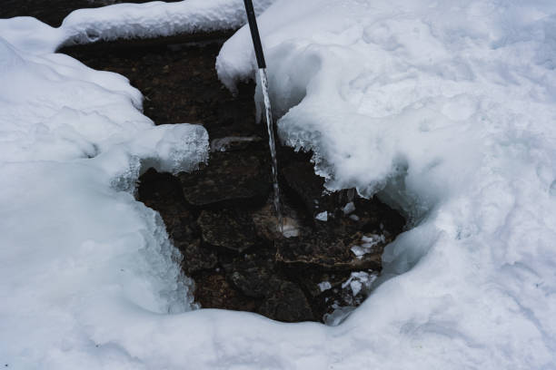 istock Clean water from a spring flows from a pipe in winter in nature. 2022497060