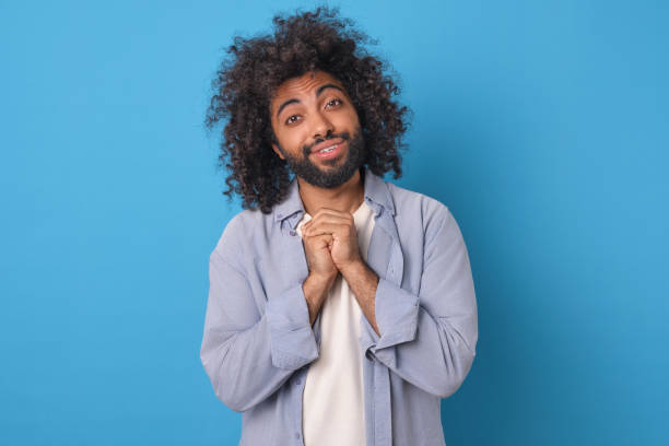 istock Young kind smiling Arabian man bows head and crosses palms making prayer gesture 2022501264