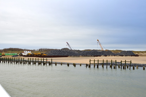 Blankenberge, West-Flanders, Belgium - February 17, 2024: To prevent the blowing sand from silting up in the marina, a dike sea wall is being built
