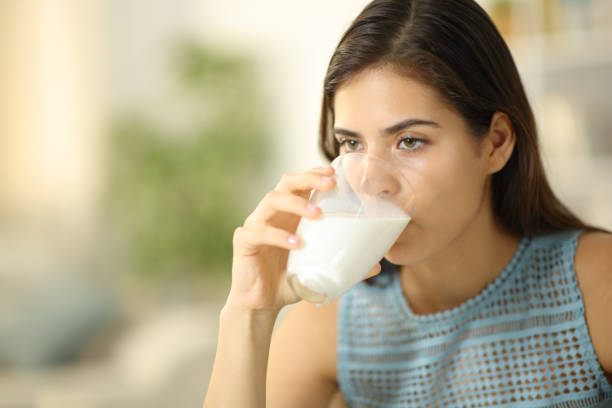 istock Serious woman drinking milk from transparent glass 2022509235