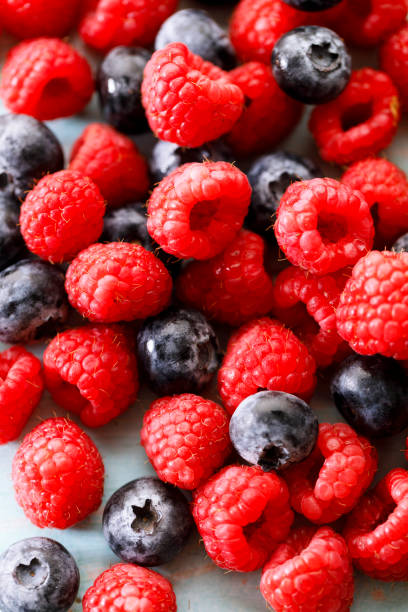 istock Blueberries and raspberries on wooden table 2022511412