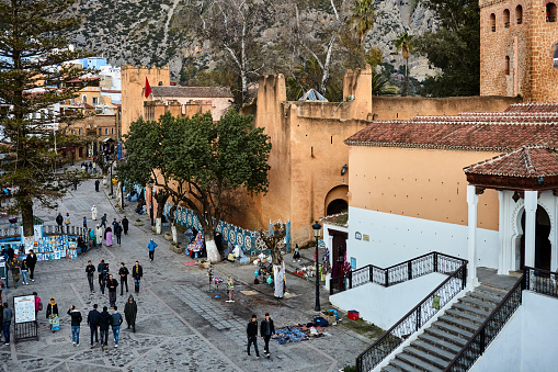 Place Outa El Hamam square with group of people at sunset in Chefchaouen, Morocco, North Africa.