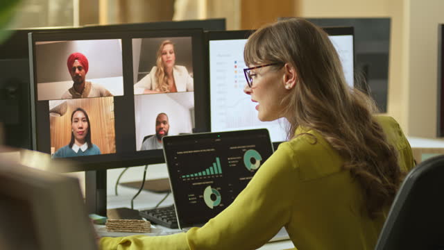 Woman having a videoconference meeting with four colleagues with her laptop in front of her