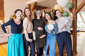 Multiracial group of friends wearing colorful sunglasses at baby shower party