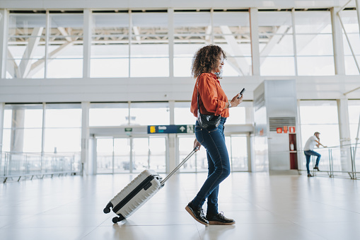 Woman walking at the airport with suitcase