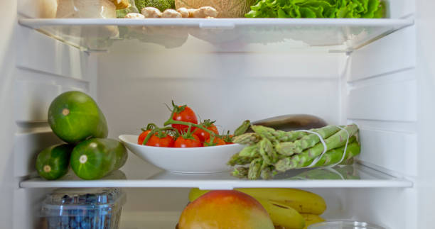 fridge stocked with fresh vegetables and fruit - refrigerator healthy eating mango fruit stock-fotos und bilder