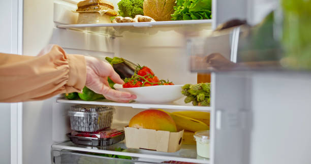 istock Woman hands taking tomato out of refrigerator 2022571237