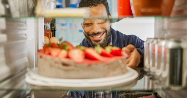 istock Man taking cake out of fridge 2022572920